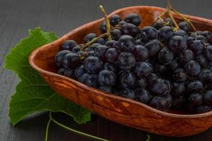Grape in a bowl on wooden background photo