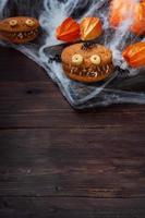 galletas con pasta de crema en forma de monstruos para la celebración de halloween. divertidas caras caseras hechas de galletas de avena y leche condensada hervida. copie el espacio foto
