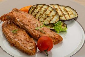 Pork steak on the plate and wooden background photo