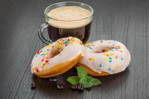 Coffee with donuts on wooden background photo