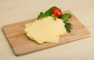 Sliced cheese on wooden board photo