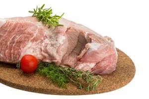 carne de cerdo cruda en placa de madera y fondo blanco foto