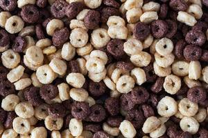 cereales de desayuno secos de fondo. aros de chocolate y maíz elaborados a base de cereales naturales. de cerca. foto