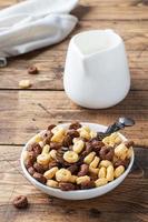 Dry breakfast cereals. Chocolate and corn rings made from natural cereals with milk in a plate. Wooden rustic background, copy space. photo