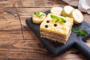 bizcocho de plátano con nueces y gotas de chocolate. delicioso postre dulce para el té, fondo de madera. vista superior, espacio de copia. foto