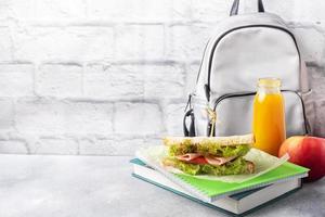 Snack for school with sandwich, fresh Apple and orange juice. Colorful school supplies, Copy space, photo