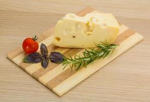 Maasdam cheese on wooden background photo