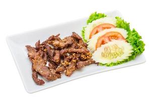 Fried pork thai style on the plate and white background photo