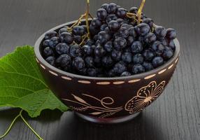 Grape in a bowl on wooden background photo