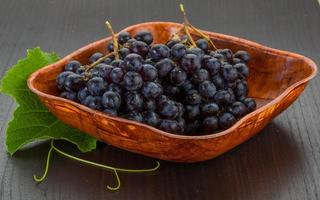 Grape in a bowl on wooden background photo