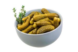 Marinated cucumbers in a bowl on white background photo