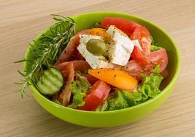 Greek salad in a bowl on wooden background photo