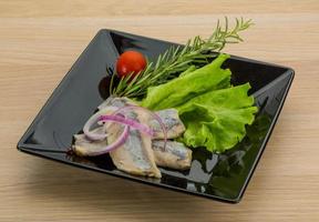 Herring fillet on the plate and wooden background photo