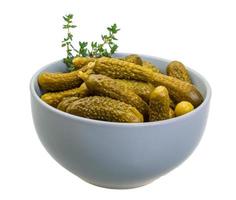 Marinated cucumbers in a bowl on white background photo