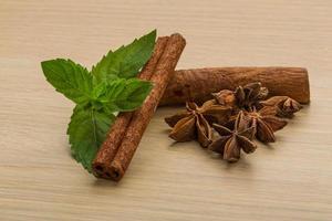 palitos de canela y anís estrellado sobre fondo de madera foto