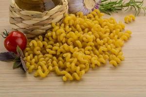 Fusilli on wooden background photo