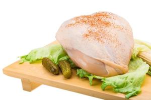 Chicken breast on wooden board and white background photo