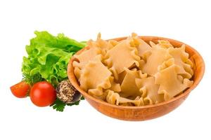 Raw pasta in a bowl on white background photo