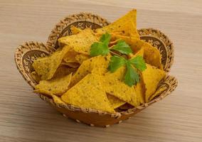 Nachos in a basket on wooden background photo