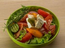 Greek salad in a bowl on wooden background photo