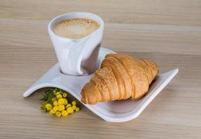 Coffee with croissant on the board photo