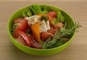 Greek salad in a bowl on wooden background photo