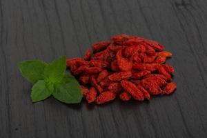 Dried goji on wooden background photo