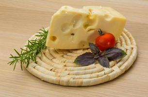 Maasdam cheese on wooden background photo