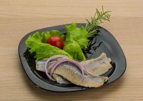 Herring fillet on the plate and wooden background photo