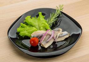 Herring fillet on the plate and wooden background photo