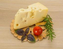 Maasdam cheese on wooden background photo