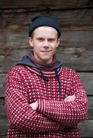 young hipster in front of wooden house photo