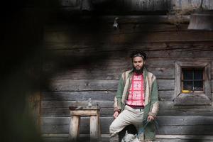 hipster with dog in front of wooden house photo