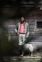 hipster con perro frente a casa de madera foto