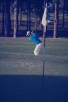 pro golfer hitting a sand bunker shot photo