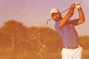 pro golfer hitting a sand bunker shot photo