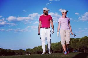 pareja caminando en campo de golf foto