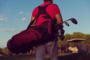 close up of golfers back while   walking and carrying golf  bag photo