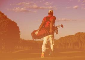 golfer  walking and carrying golf  bag photo