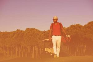 golfer  walking and carrying golf  bag photo