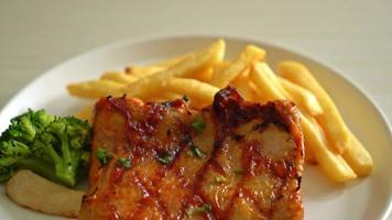 grilled chicken steak with potato chips or french fries on white plate