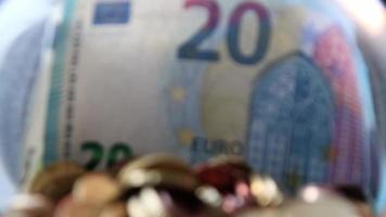 Euro-Geld-Einsparungen, die in ein Glasgefäß voller Euro-Münzen und Euro-Banknoten gleiten, für die Finanzverwaltung von Taschengeld und Trinkgeld oder Trinkgeld für Sparschwein-Währungsstapel als Bargeld-Nahaufnahme-Makroansicht video