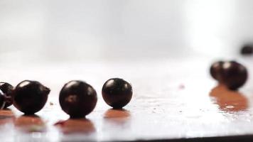 Black currant berries fall on the table at home in the kitchen. Fruits and berries are healthy food. Cook at home. Footage clip stock video