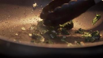 The chef pours cream on the spinach and interferes with a spatula. Close-up Cook frying cream in a pan with spinach and onions. Boiling Soup On The Restaurant Stov video