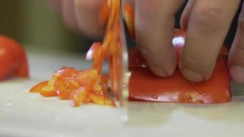 Male hands clean cut organic sweet pepper paprika. Close-up of a male cook's hands cutting fresh paprika with a knife video