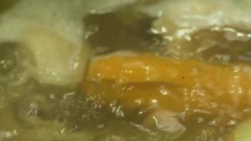 cierra la sopa hirviendo en una olla. el caldo asiático verduras picadas zanahorias, patatas en una olla. video