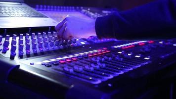 elektrische maschine auf dem tisch zum arbeiten des sounddesigners oder club-dj auf einer party im nachtclub in neonblauer und violetter beleuchtung. beruf für modernen lebensstil video