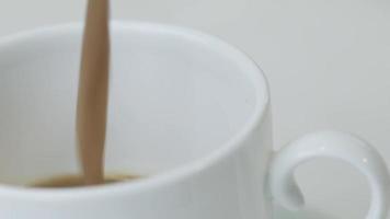 taza de café sobre una mesa blanca con granos de café. material de archivo de vídeo. video