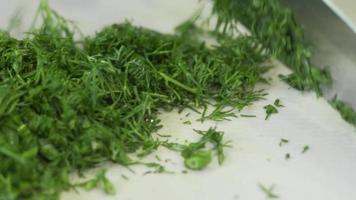 Fresh greens salad, parsley and dill on the table in the kitchen. video