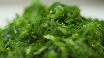 Fresh greens salad, parsley and dill on the table in the kitchen. video